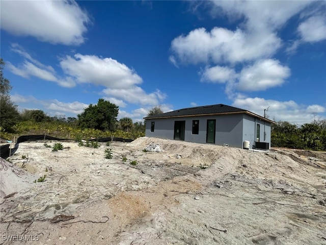 rear view of property featuring cooling unit and stucco siding