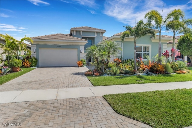 28589 Wharton Dr, Bonita Springs, FL 34135 - view of front of home featuring a garage, decorative driveway, a tile roof, and stucco siding