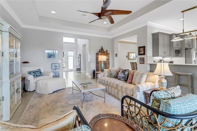 28589 Wharton Dr, Bonita Springs, FL 34135 - living room with visible vents, a tray ceiling, ceiling fan, and ornamental molding