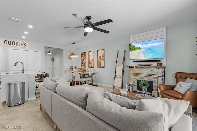 living area with light tile patterned floors, visible vents, recessed lighting, ceiling fan, and a stone fireplace