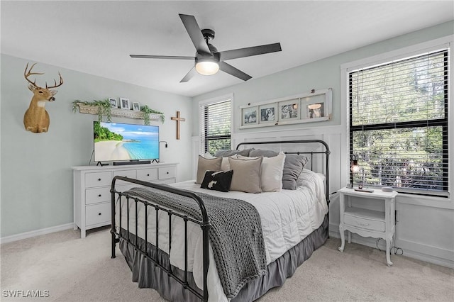 bedroom featuring a ceiling fan, baseboards, and light carpet