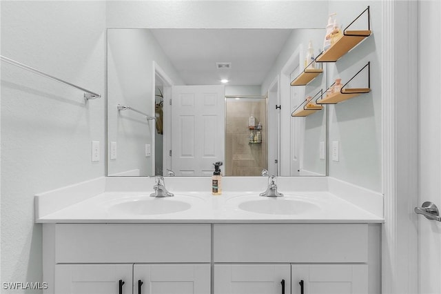 bathroom with double vanity, walk in shower, and a sink