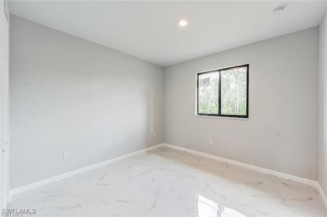 spare room with marble finish floor, baseboards, and recessed lighting