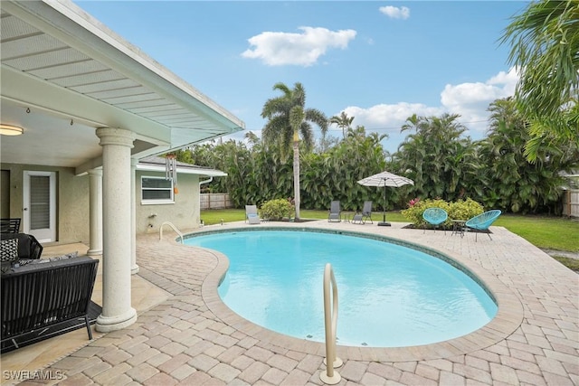 outdoor pool with a lawn and a patio