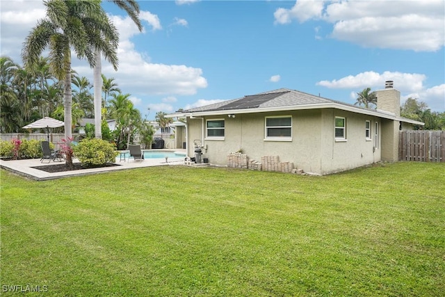 rear view of house with a yard, a fenced backyard, a patio, and stucco siding