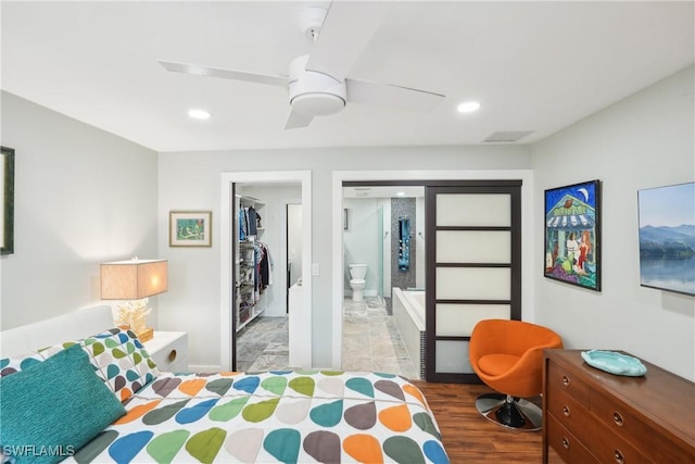 bedroom featuring ceiling fan, connected bathroom, recessed lighting, wood finished floors, and a spacious closet