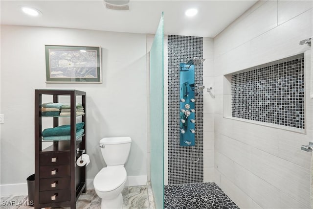 bathroom featuring toilet, baseboards, tiled shower, and recessed lighting