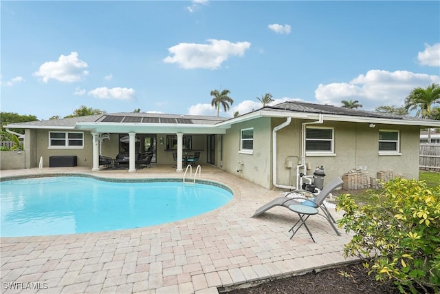 outdoor pool with a patio and fence