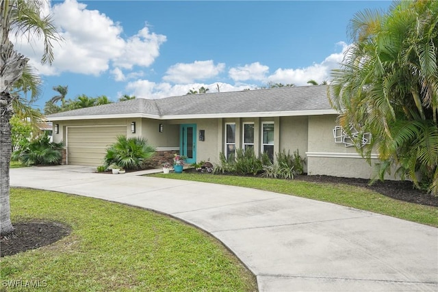 ranch-style home featuring an attached garage, concrete driveway, roof with shingles, stucco siding, and a front lawn