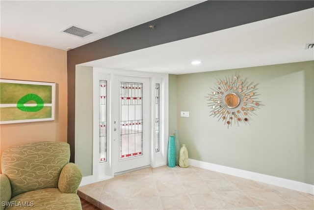 doorway with light tile patterned floors, baseboards, and visible vents