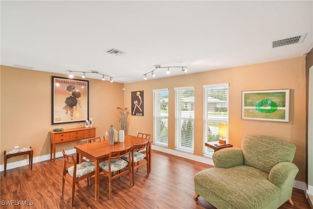 dining space featuring wood finished floors, visible vents, and baseboards