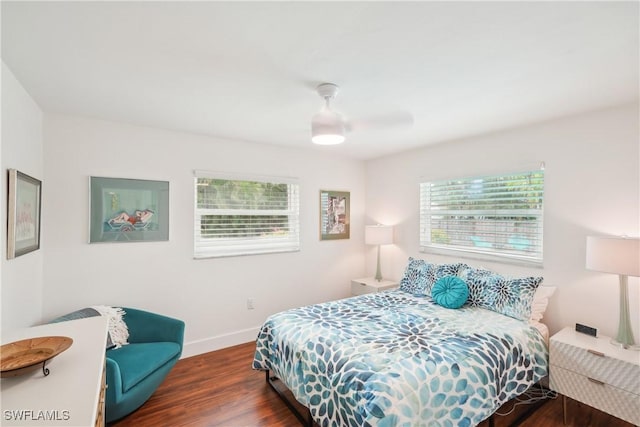 bedroom with ceiling fan, wood finished floors, and baseboards