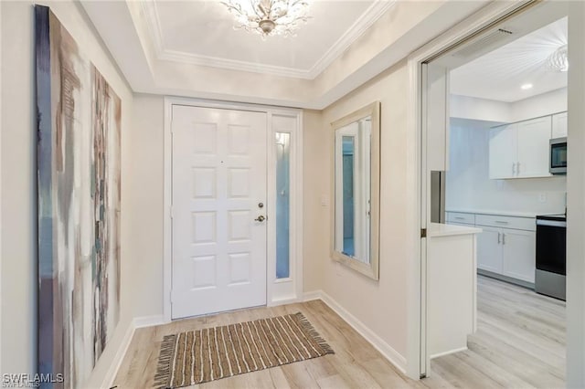 entrance foyer with light wood-type flooring, baseboards, ornamental molding, and a notable chandelier