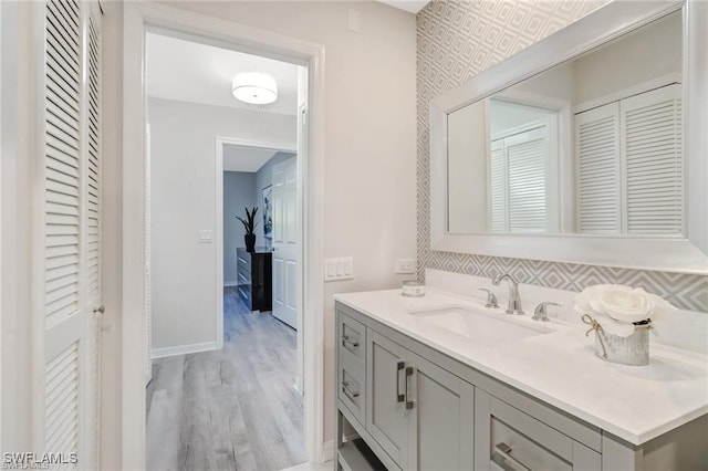 bathroom with vanity, baseboards, and wood finished floors