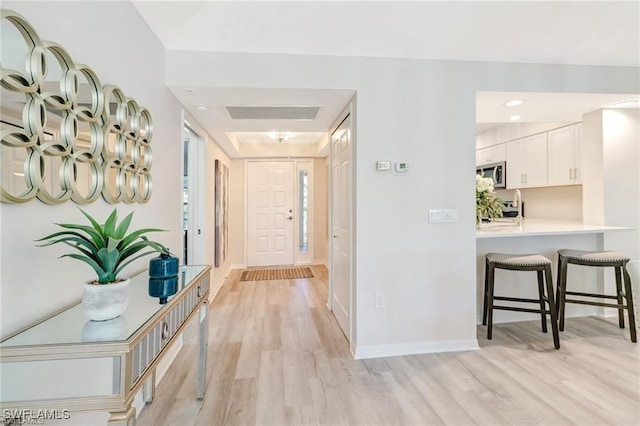 hall with light wood-type flooring and baseboards