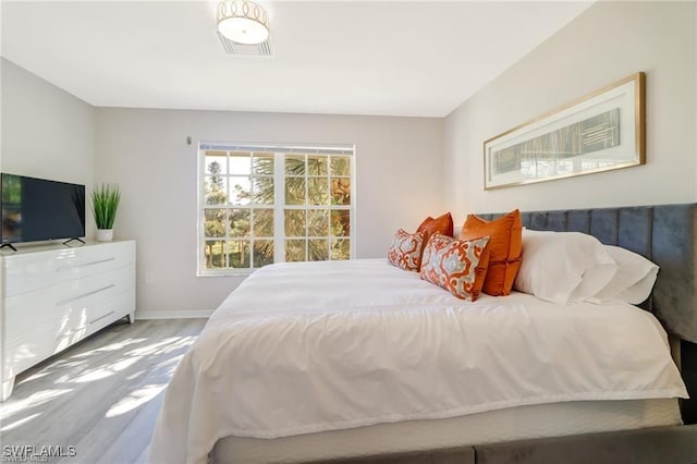 bedroom with baseboards and wood finished floors