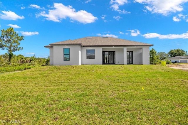 back of house with a lawn and stucco siding