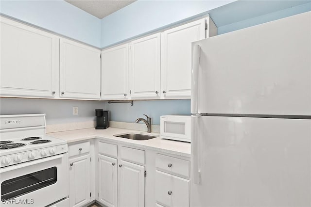 kitchen featuring white appliances, a sink, and white cabinets