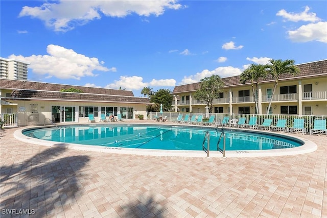 community pool featuring a patio area and fence