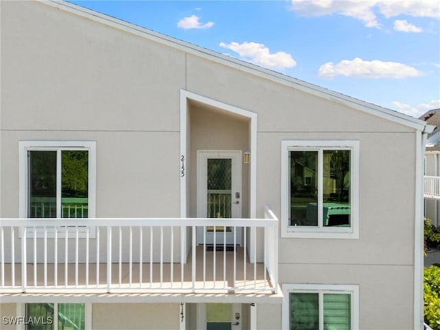 exterior space featuring a balcony and stucco siding