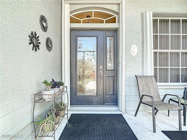 property entrance with stucco siding