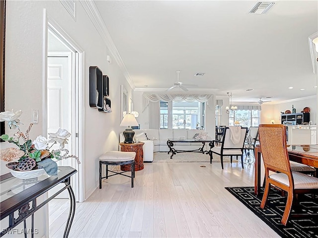 interior space featuring visible vents, crown molding, light wood-style floors, and a ceiling fan