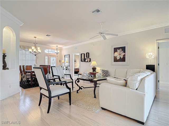 living area featuring visible vents, ceiling fan with notable chandelier, light wood-type flooring, and crown molding