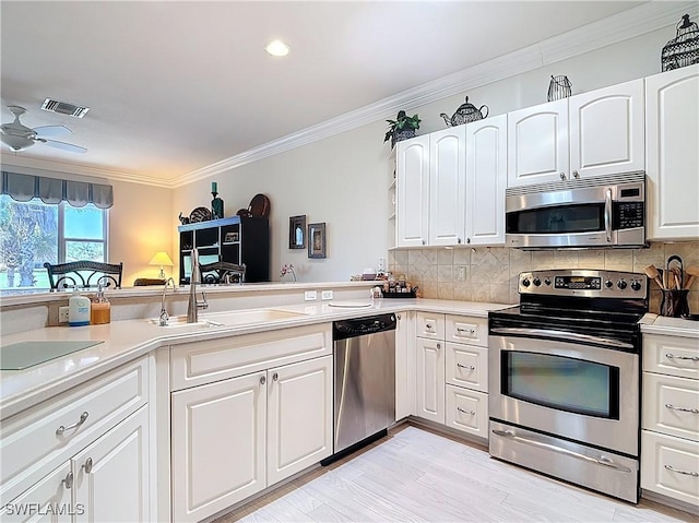 kitchen with visible vents, backsplash, light countertops, ornamental molding, and appliances with stainless steel finishes