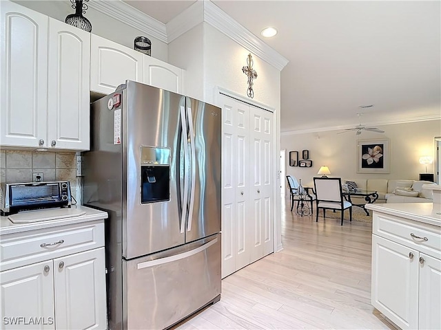 kitchen with light wood finished floors, backsplash, stainless steel refrigerator with ice dispenser, and ornamental molding