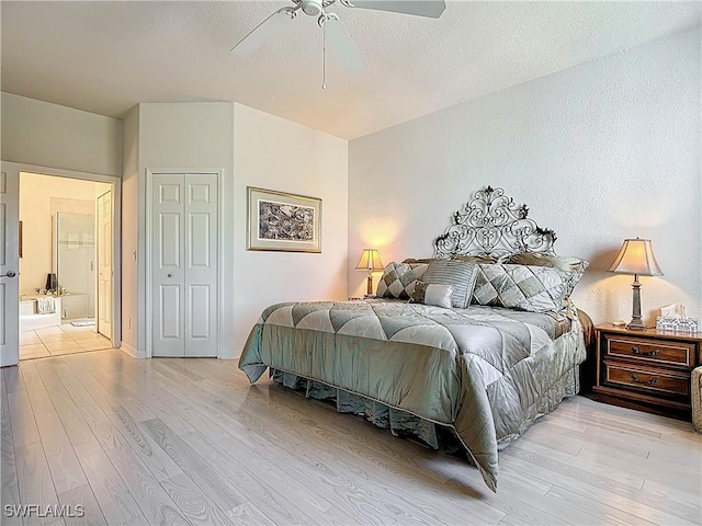 bedroom featuring light wood-type flooring, a textured ceiling, a closet, and a ceiling fan