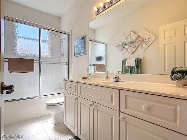 full bath featuring vanity, toilet, tile patterned flooring, and enclosed tub / shower combo