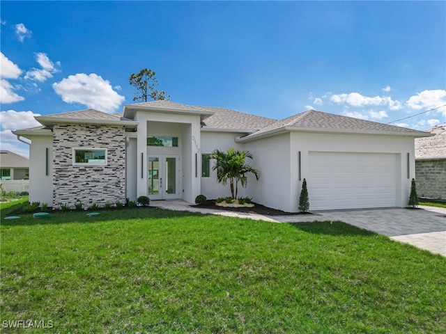 prairie-style home featuring an attached garage, decorative driveway, french doors, a front lawn, and stucco siding