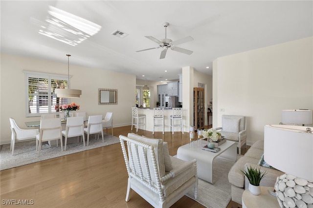 dining area featuring light wood-type flooring, a wealth of natural light, visible vents, and a ceiling fan