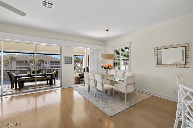 dining area featuring wood finished floors, visible vents, and baseboards