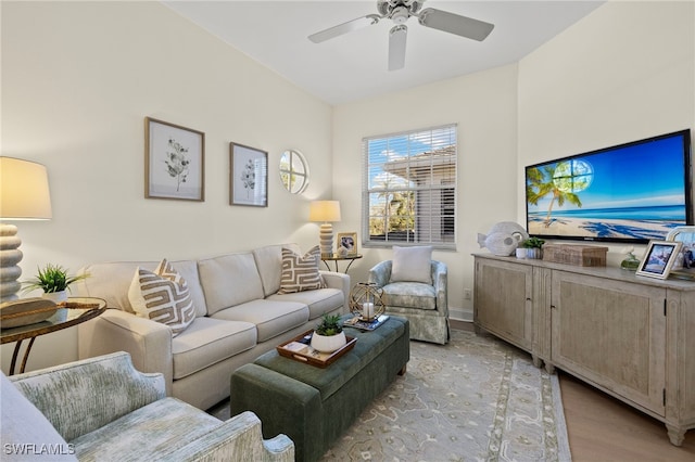 living area featuring light wood-style floors, ceiling fan, and baseboards