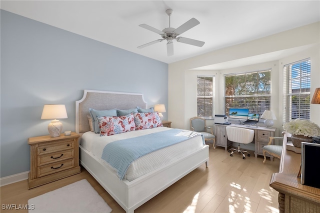 bedroom with light wood-type flooring, a ceiling fan, and baseboards