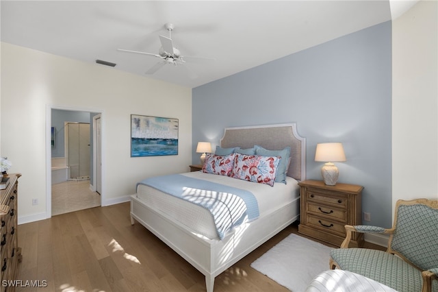 bedroom featuring ensuite bathroom, wood finished floors, a ceiling fan, visible vents, and baseboards