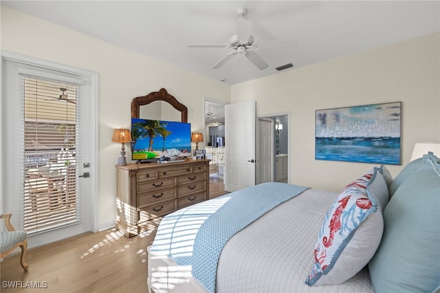 bedroom featuring visible vents, ensuite bath, ceiling fan, wood finished floors, and access to outside