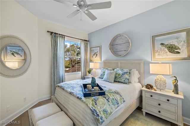 bedroom featuring a ceiling fan, baseboards, and wood finished floors