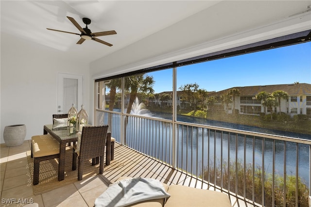 sunroom / solarium featuring a water view and ceiling fan