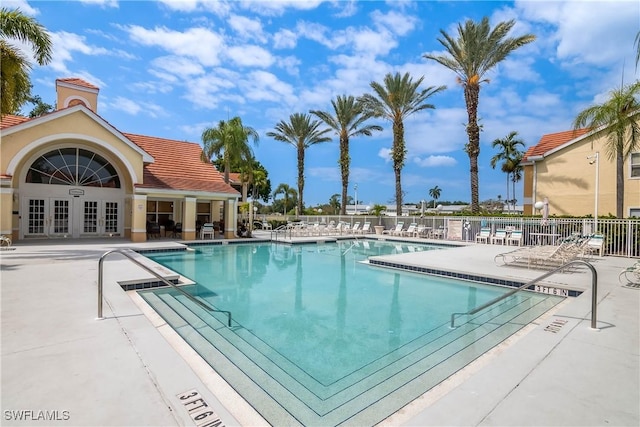 pool featuring a patio, french doors, and fence