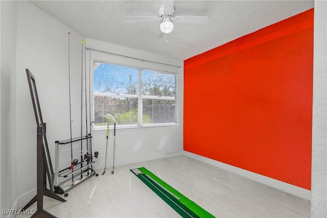 empty room featuring ceiling fan, baseboards, and a textured ceiling