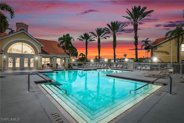 community pool with fence, french doors, and a patio