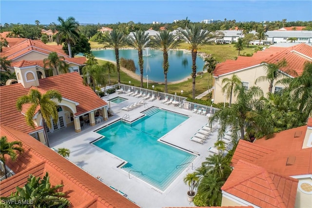 pool with a water view, fence, and a patio