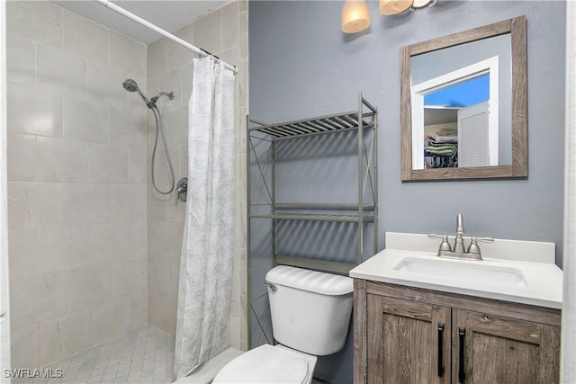 bathroom with vanity, a shower stall, and toilet