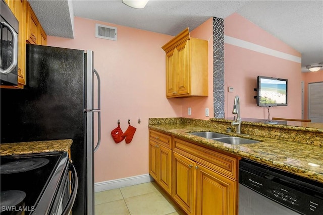 kitchen featuring light tile patterned floors, visible vents, appliances with stainless steel finishes, stone countertops, and a sink