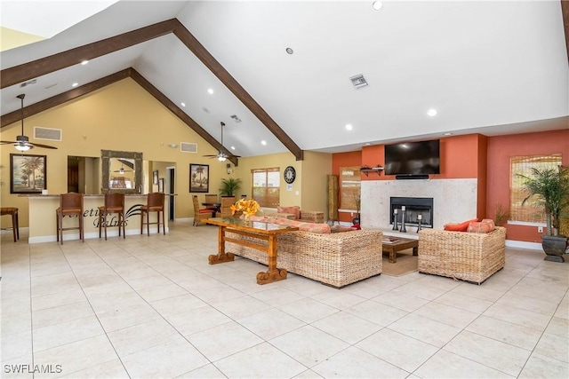 living area featuring light tile patterned floors, a fireplace, visible vents, and beamed ceiling