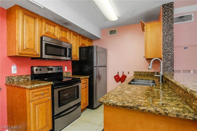 kitchen featuring stainless steel appliances, light tile patterned flooring, a sink, and visible vents