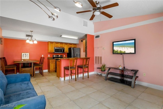 living area featuring lofted ceiling, visible vents, and baseboards