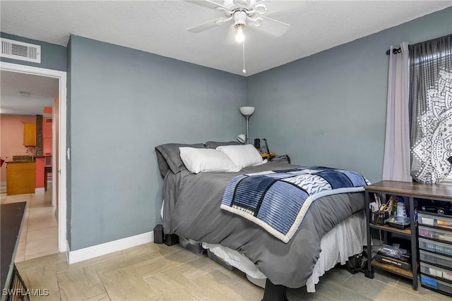 bedroom with visible vents, baseboards, and a textured ceiling